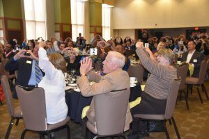 Attendees making a heart shape with their hands at Lights On Luncheon