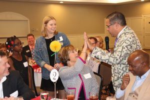 Rafael Sanchez high-fiving AYS board member at Lights On Luncheon 2018